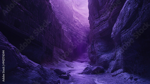 A striking image of a narrow canyon with towering rock walls that extend vertically upwards. The texture of the rocks is rugged and jagged, creating a dramatic sense of depth. The lighting in the cany photo