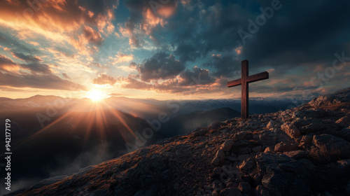 A cross is on a mountain top with a beautiful sunset in the background