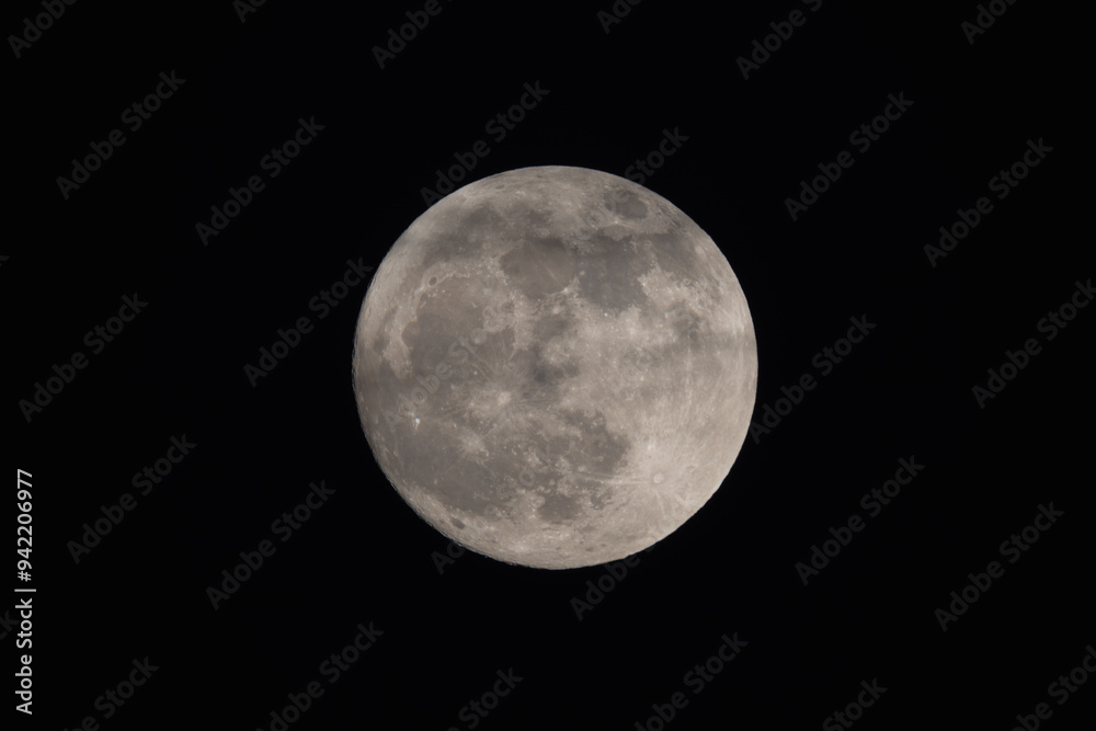 photograph of the full moon partially covered with clouds photograph of the full moon partially covered with clouds