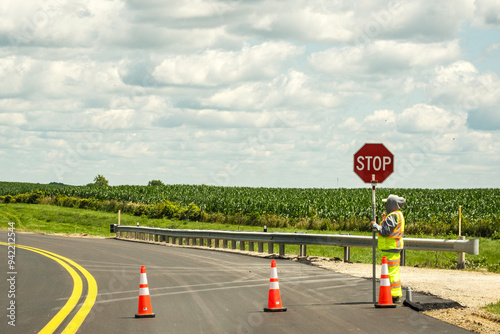 Road worker with stop sign on a rural highway