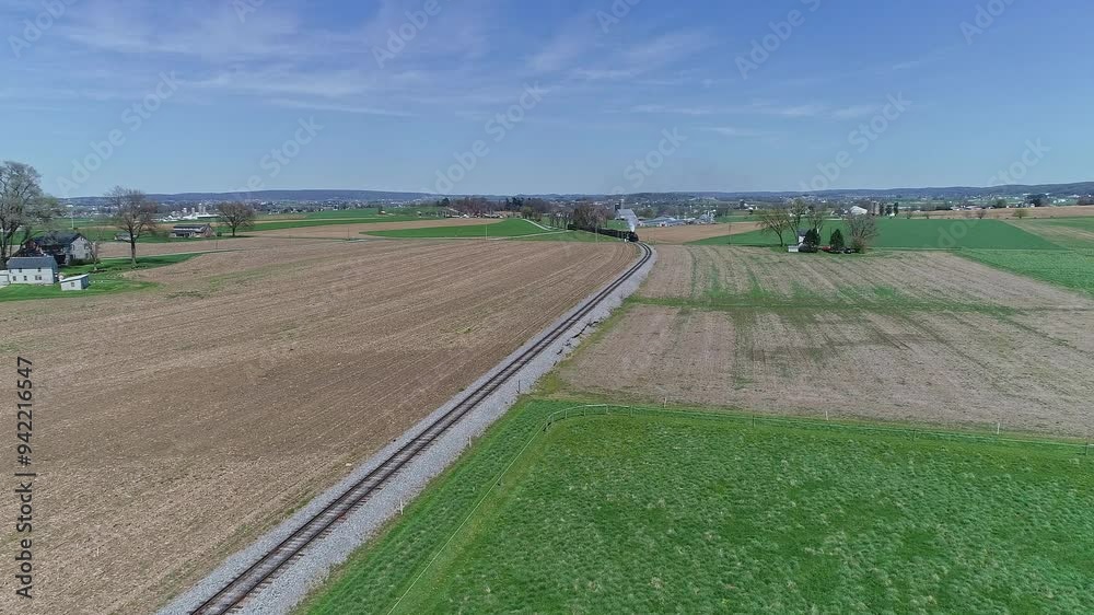 Tranquil Rural Landscape With Railroad Tracks in a Green Field Under Clear Blue Sky Tranquil Rural Landscape With Railroad Tracks in a Green Field Under Clear Blue Sky