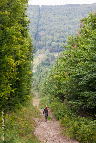 A man hikes on the border swath between Easton, Maine and Bath, New Brunswick. Part of the International Appalachian Trail. (MR)
