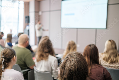 Group of people attentively listening to a speaker in a professional seminar setting, showcasing learning and engagement