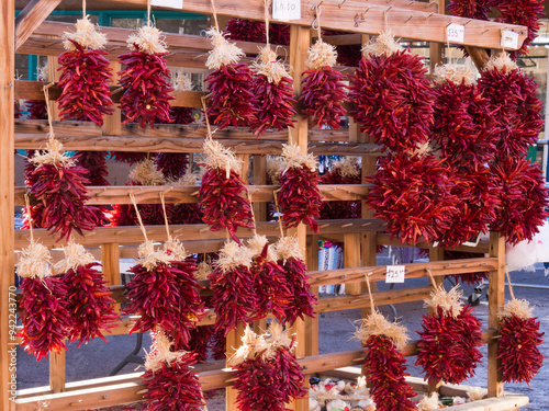 USA, New Mexico, Sante Fe. Large groups of hot red chili peppers hanging on a display in Sante Fe.