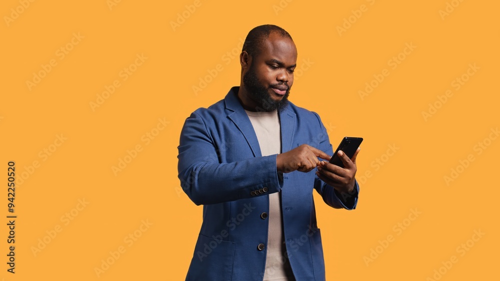 Portrait of energetic happy man holding smartphone celebrating, throwing fists in air from excitement. Overjoyed BIPOC person reading good news on phone, cheering, studio background, camera B Portrait of energetic happy man holding smartphone celebrating, throwing fists in air from excitement. Overjoyed BIPOC person reading good news on phone, cheering, studio background, camera B
