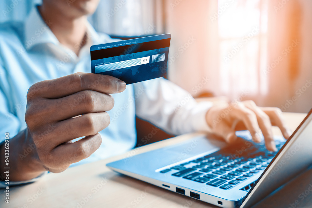 Young man use credit card for shopping payment online on laptop computer application or website. E-commerce and online shopping concept. uds Young man use credit card for shopping payment online on laptop computer application or website. E-commerce and online shopping concept. uds