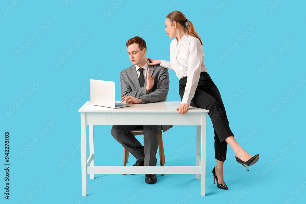 Business woman seducing her male colleague at table on blue background. Harassment concept