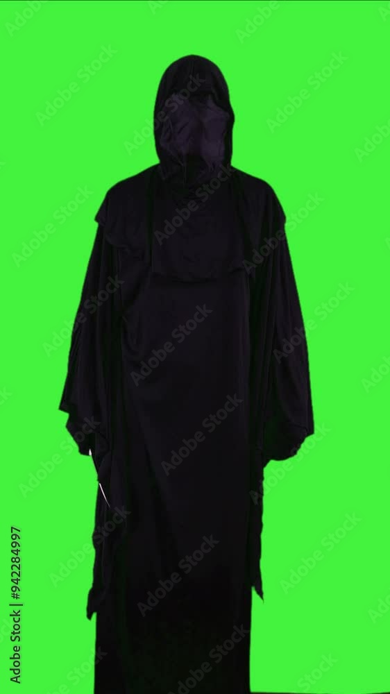 vertical Grim reaper in Halloween costume with a knife threatening to cut neck on a green screen