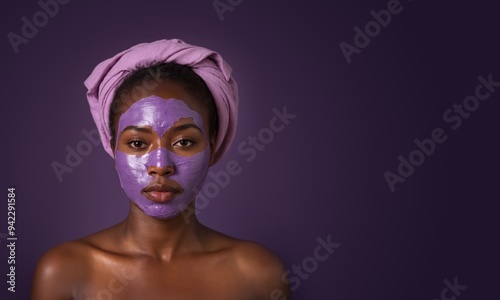 Attractive woman wearing vitamin facial cream mask on her face on simple purple background. Healthcare, beauty treatment and wrinkles prevention wide banner concept with copy space.