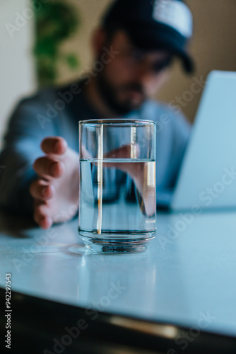 young man holding a glass of water (vertical photo)