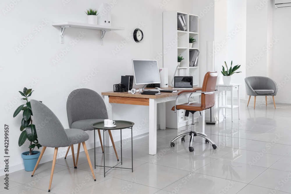 Fototapeta premium Stylish interior of light office with workplace, modern computer, laptop and armchair