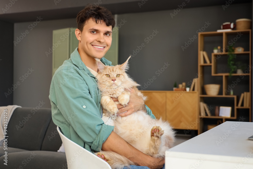 Handsome young happy man with cute Maine Coon cat at home Handsome young happy man with cute Maine Coon cat at home