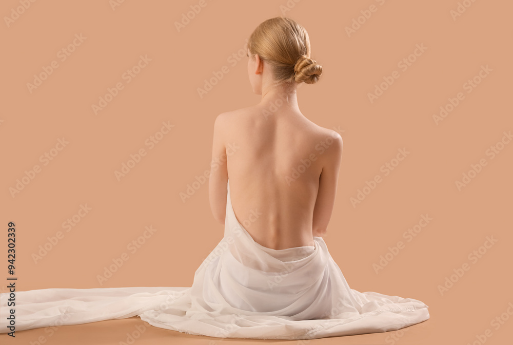 Beautiful young woman with fabric and naked back sitting on brown background Beautiful young woman with fabric and naked back sitting on brown background