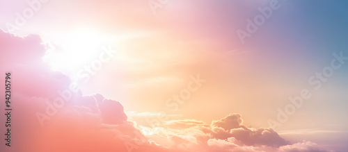 Dreamy Romantic Sky scape - beautiful wide peach and dusky pale blue sky and cloud scape with a burst of sunlight emerging from under the cloud base with plenty of copy space