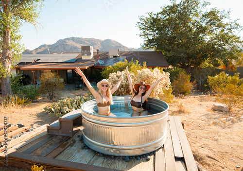 Two sweet girls pose in a cowboy tub in Joshua Tree, California.