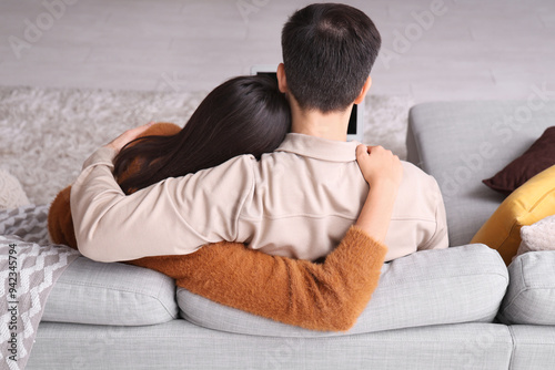 Young couple hugging at home on autumn day, back view