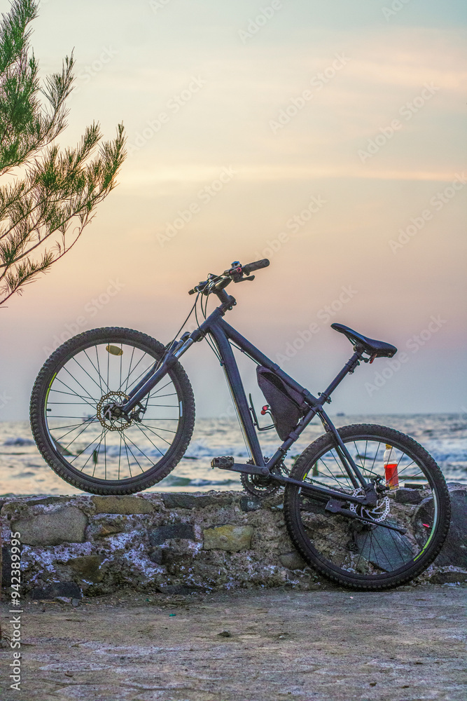 Bicycle on the beach barrier at sunset Bicycle on the beach barrier at sunset