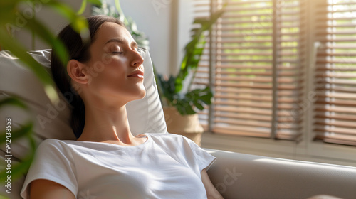 Woman relaxing in front of a fan on a hot day, cooling off in a sunny living room