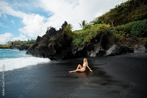 Attractive blonde woman posing on black beach, Maui, Hawaii