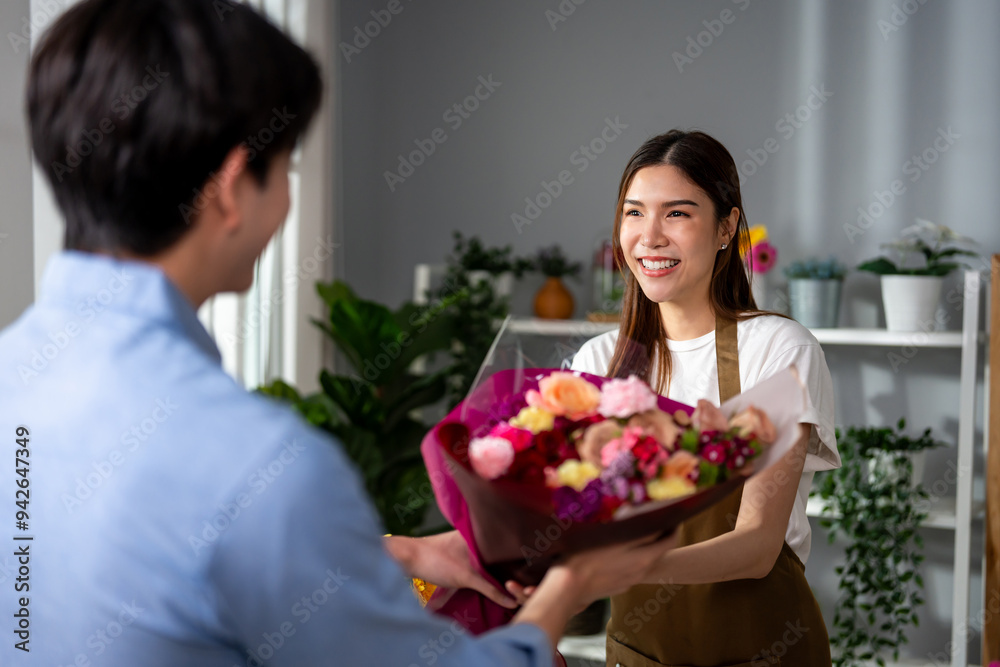 Asian young florist girl selling beautiful bouquet to customer in shop. Asian young florist girl selling beautiful bouquet to customer in shop.