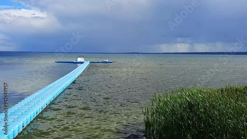 pier going into the distance against the background of a thunderstorm on the lake. summer, thunderstormy weather