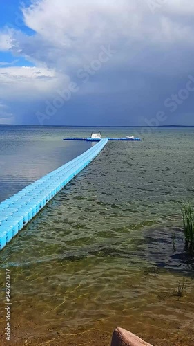 pier going into the distance against the background of a thunderstorm on the lake. summer, thunderstormy weather
