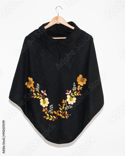 Hand embroidered sheep wool poncho, colorful, flower embroidery, black poncho on white background, no people, Ecuadorian poncho, Andean, handicraft.