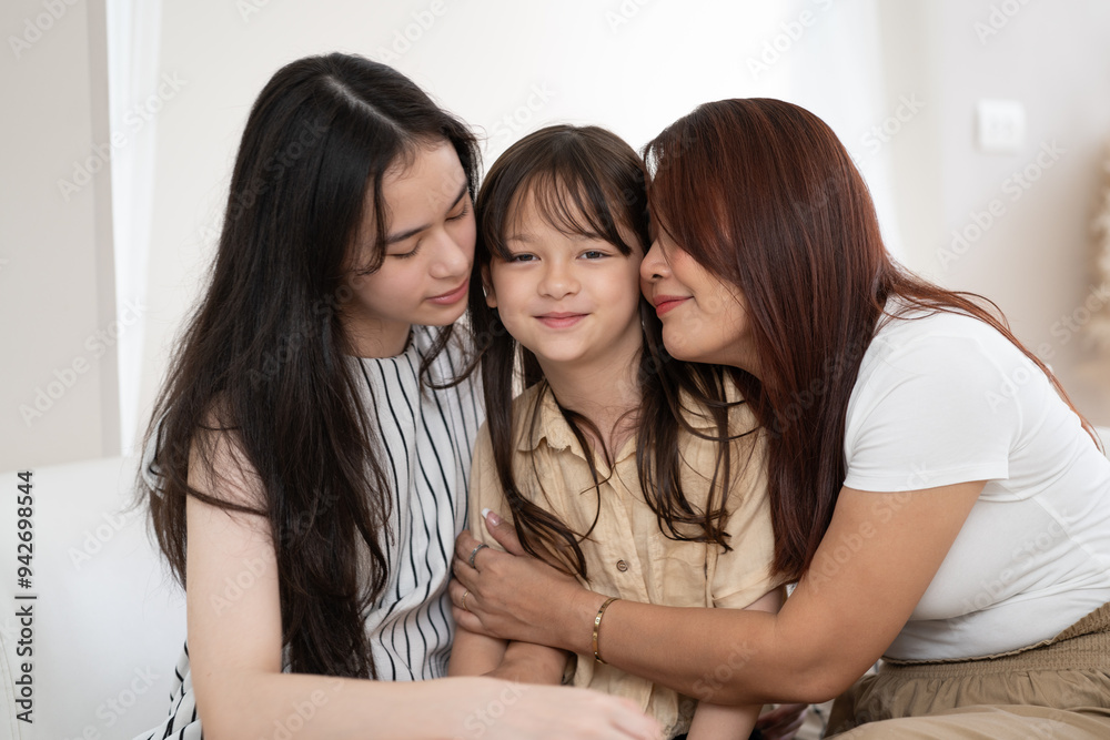 Mother and daughter hug to little daughter with little daughter smiling at home Mother and daughter hug to little daughter with little daughter smiling at home