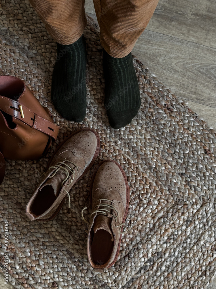 Φωτογραφία Women's legs in corduroy trousers, suede oxford boots, leather bag on a jute car