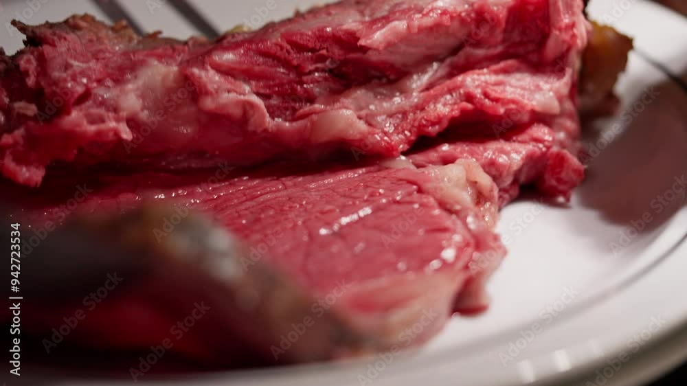Close-up of thick roast beef being sliced and placed on a hot plate, revealing the tender, juicy interior and perfectly seared crust. Steam and sizzle the rich, savory aroma. High quality 4k footage Close-up of thick roast beef being sliced and placed on a hot plate, revealing the tender, juicy interior and perfectly seared crust. Steam and sizzle the rich, savory aroma. High quality 4k footage