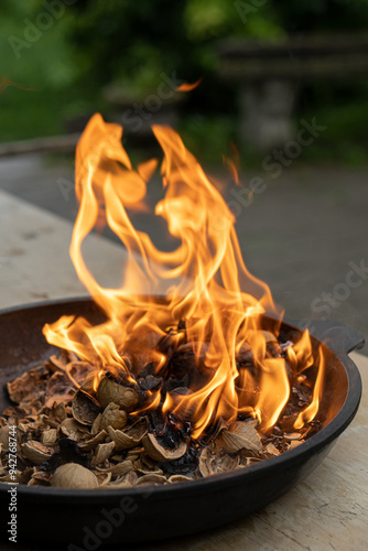 Cooking walnut ash in a cast iron pot. Open fire.