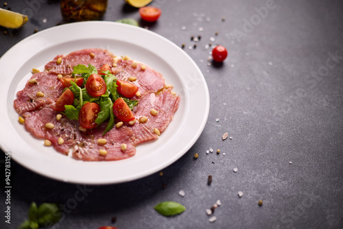 cooking tuna carpaccio - Fresh raw tuna fillet with olive oil and pine nuts on white ceramic plate