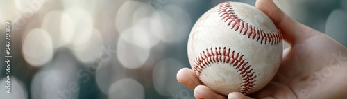 Wallpaper Mural hand holding a baseball, showcasing the sport's classic design against a blurred background. Torontodigital.ca