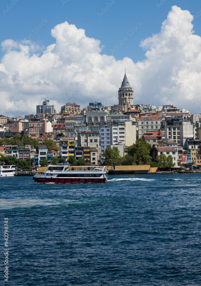 Fototapeta premium Istanbul, Turkey - August 10, 2024: Panoramic view of Galata Tower and ancient architecture in the historic part of the city on the shores of the Sea of ​​Marmara and tourist boats on a sunny summer