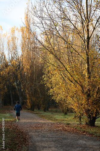 Man running in park at autumn morning