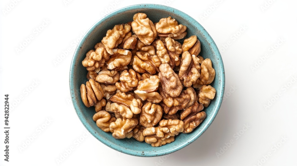 Shelled walnut halves in a bowl. These walnut tree seeds are used as snacks or for baking. Close-up overhead isolated shot on a white background. Shelled walnut halves in a bowl. These walnut tree seeds are used as snacks or for baking. Close-up overhead isolated shot on a white background.
