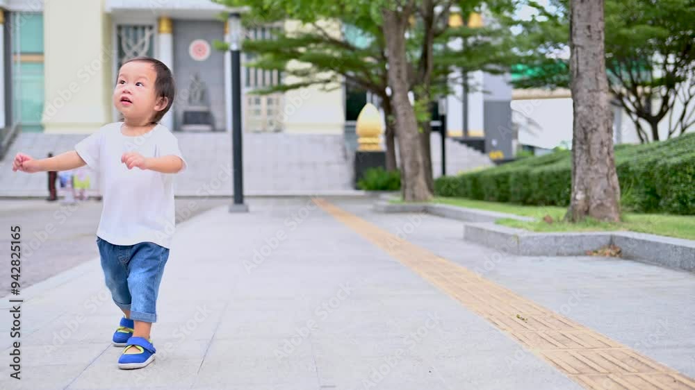 Asian boy is walking in the evening on the pedestrian walkway, in summer or spring time, the Child walks and jogs happily. The kid is 1-2 years old. Asian boy is walking in the evening on the pedestrian walkway, in summer or spring time, the Child walks and jogs happily. The kid is 1-2 years old.