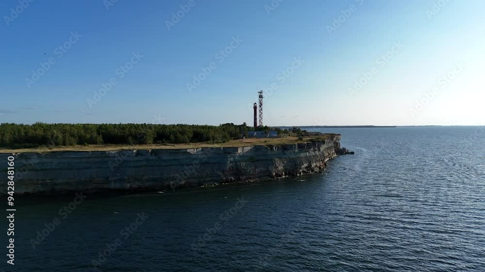 Aerial View of Pakri Cliff with Lighthouse and Sea, Paldiski, Estonia. Aerial view of Pakri Cliff, Paldiski, Estonia, featuring a red lighthouse, calm blue sea, and speedboat passing by. Aerial View of Pakri Cliff with Lighthouse and Sea, Paldiski, Estonia. Aerial view of Pakri Cliff, Paldiski, Estonia, featuring a red lighthouse, calm blue sea, and speedboat passing by.