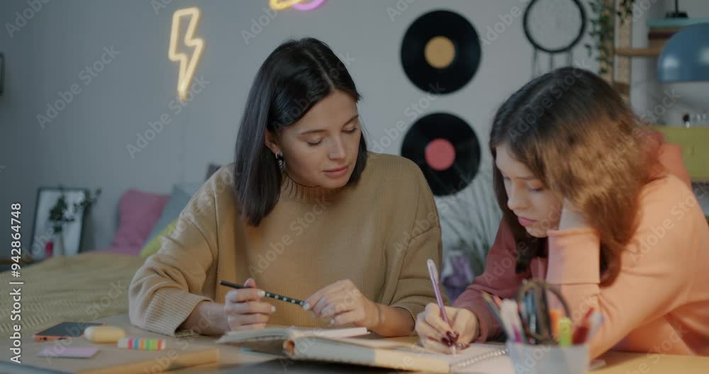 Teenage girl doing homework feeling tired and sad while loving mother helping and expressing support at home in evening. Family and education concept.