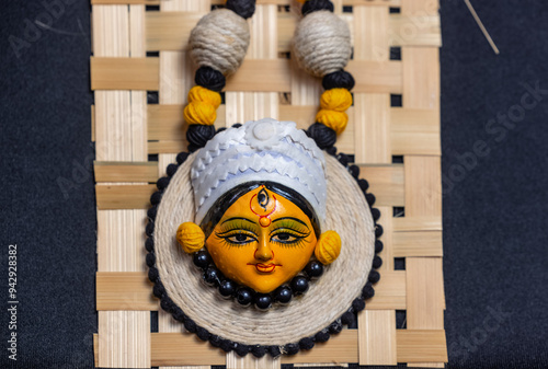 Subho mahalaya, hindu goddess durga idol handmade necklace painted with yellow color with plain background. Jewellery concept. photo