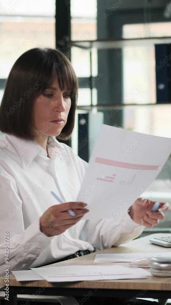 Pensive Caucasian female office worker overview financial documents, developing startup strategy and accounting business in the office. Vertical video. Pensive Caucasian female office worker overview financial documents, developing startup strategy and accounting business in the office. Vertical video.