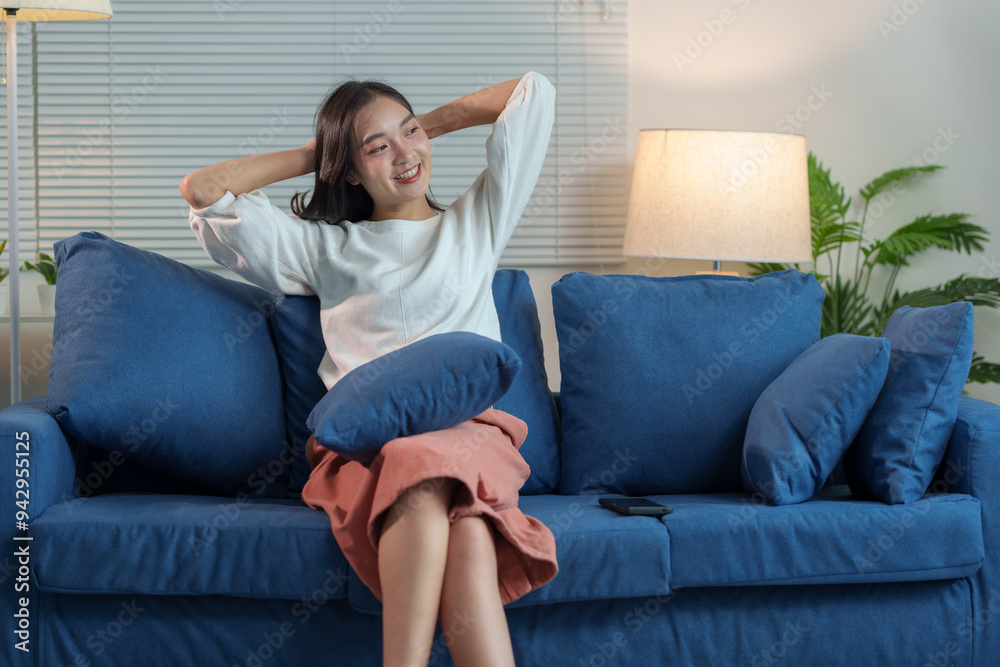Beautiful smiling Asian woman sitting and relaxing Relax happily at home on the sofa. Watching TV in the living room at home on the weekends. Lifestyle concept. Beautiful smiling Asian woman sitting and relaxing Relax happily at home on the sofa. Watching TV in the living room at home on the weekends. Lifestyle concept.