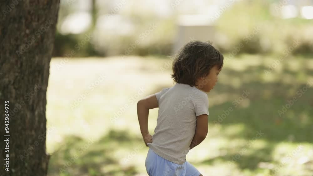 Joyful toddler running freely in a sunny park filled with lush greenery Joyful toddler running freely in a sunny park filled with lush greenery