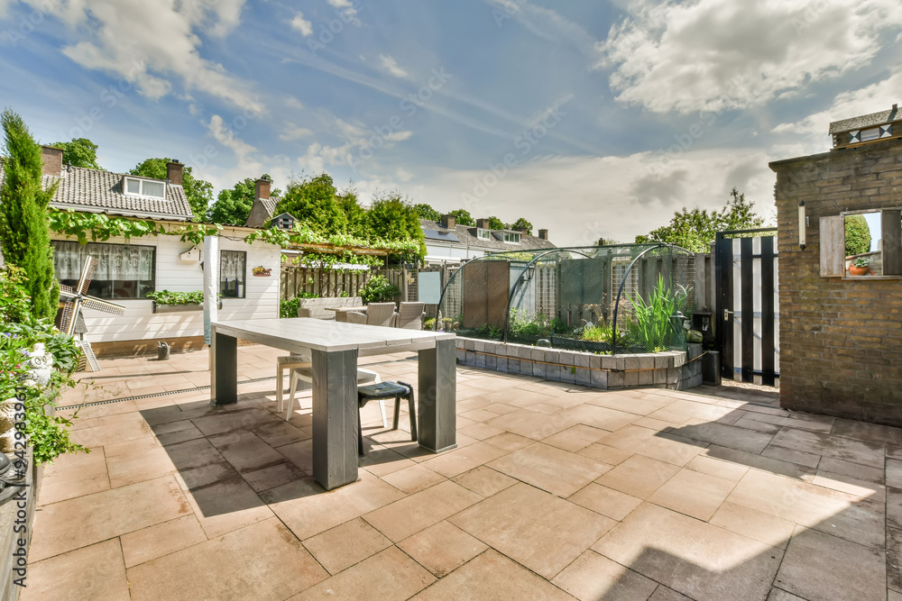 Sunny suburban backyard with patio and garden furniture Sunny suburban backyard with patio and garden furniture