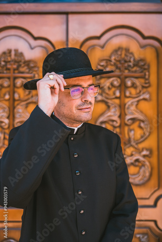 Catholic priest adjusts his hat outside church in Altea