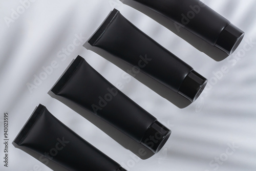 Elegant Black Cosmetic Tubes Floating on White