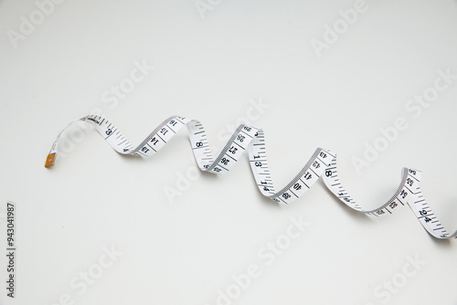Top view of a curled measuring tape on a white background
