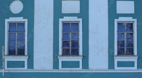 Three rectangular windows on the ground floor of the house