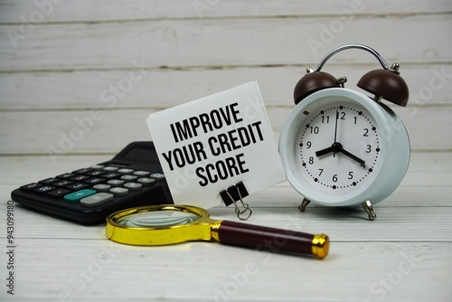 Improve Your Credit Score text on paper card with alarm clock, calculator and magnifying glass on wooden background photo