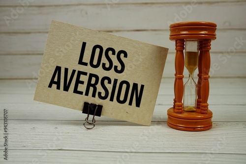 Loss Aversion text on paper card with Hourglass on